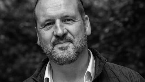portrait noir et blanc de face de Nicolas Feuz souriant